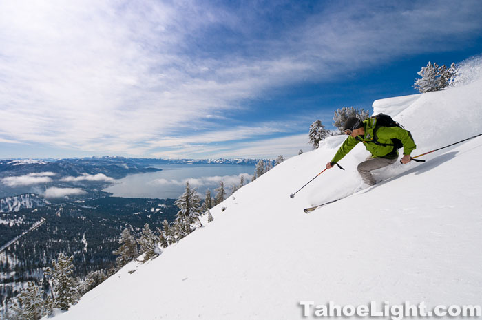 winter skiing above lake tahoe skier making turns withe lake tahoe in background