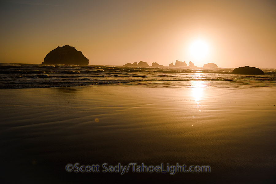 The unique rock structures along Bandon Beach all have names. The Face rock is to the left, Cat and Kittens rocks are just below the setting sun.