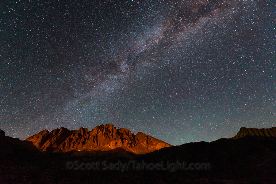 Milky way rising over a moonlit Thunderbolt Peak and North Palisade peak from the middle Barrett Lake in the Palisade Basin in the High Sierra mountain range in California.