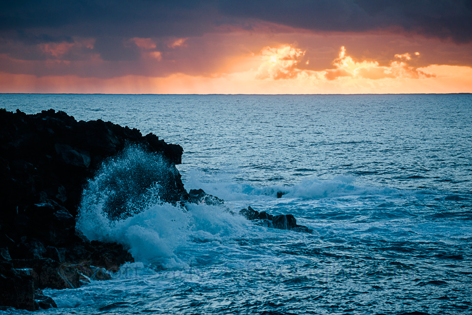 Sunset and waves crashing along the coast of lower Puna on the big island of Hawaii.