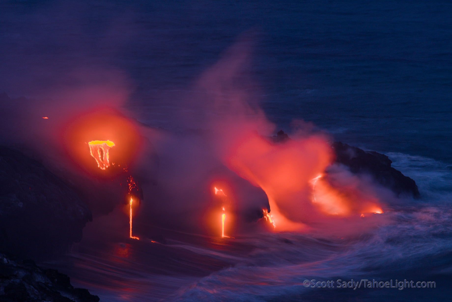 Lava entering the sea from the Volcano National Park side in Hawaii. Give yourself several days if you want good photographs, in this day, the only day there was a clear view of the sea entry from land like this, there were sustained 30 mph winds blowing fumes and making any telephoto work on a tripod impossible.