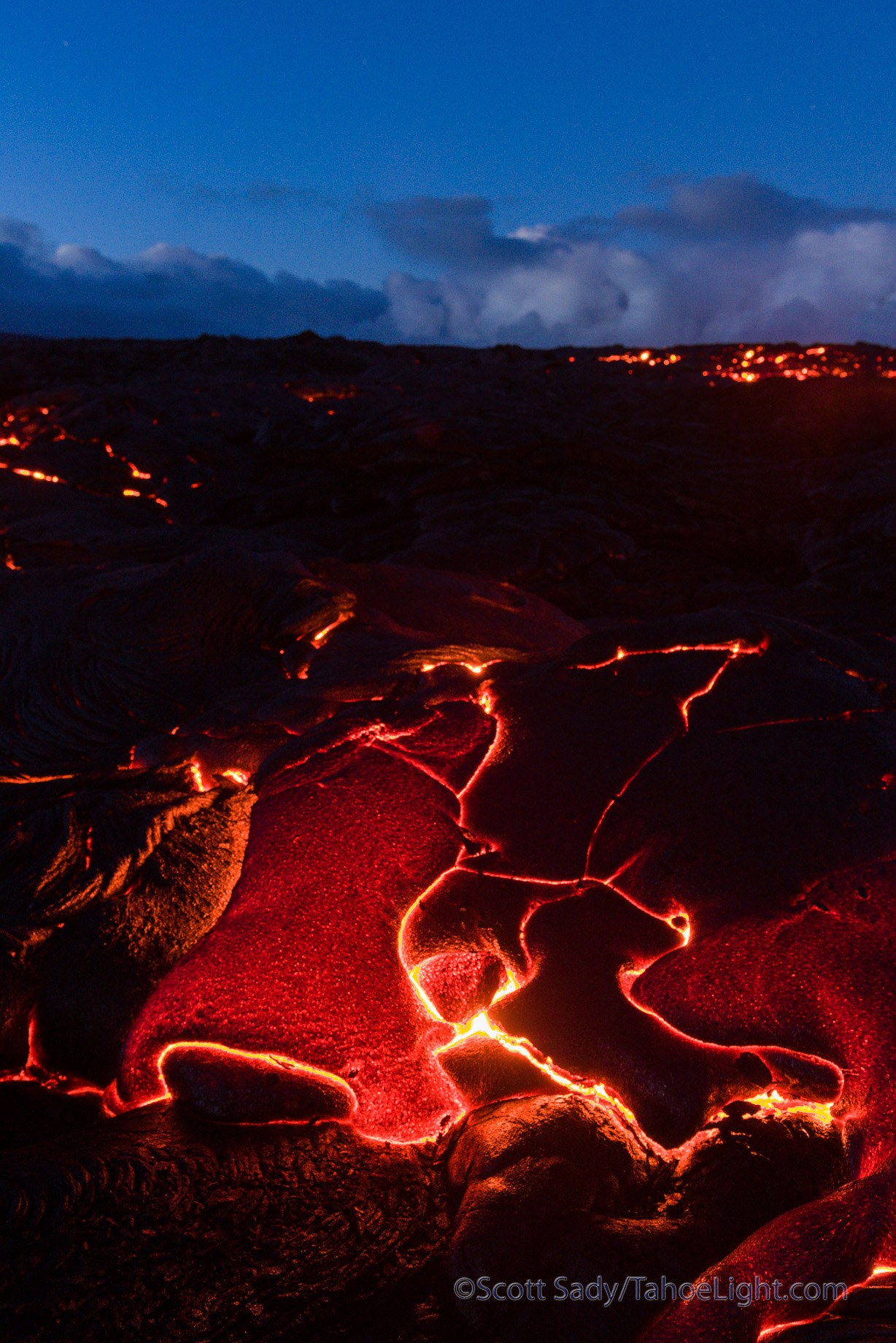Photographically the lava presents many problems. During the day, even the big flowing breakouts appear a dull orange. During the blue of dusk and dawn things look the best to me, but if you have any breakout, or moving lava, it is so intensely yellow and bright that it was impossible to photograph with a digital camera without going out of gamut. So I started looking for formations that were starting to cool and no longer moving and found those balanced out the best.