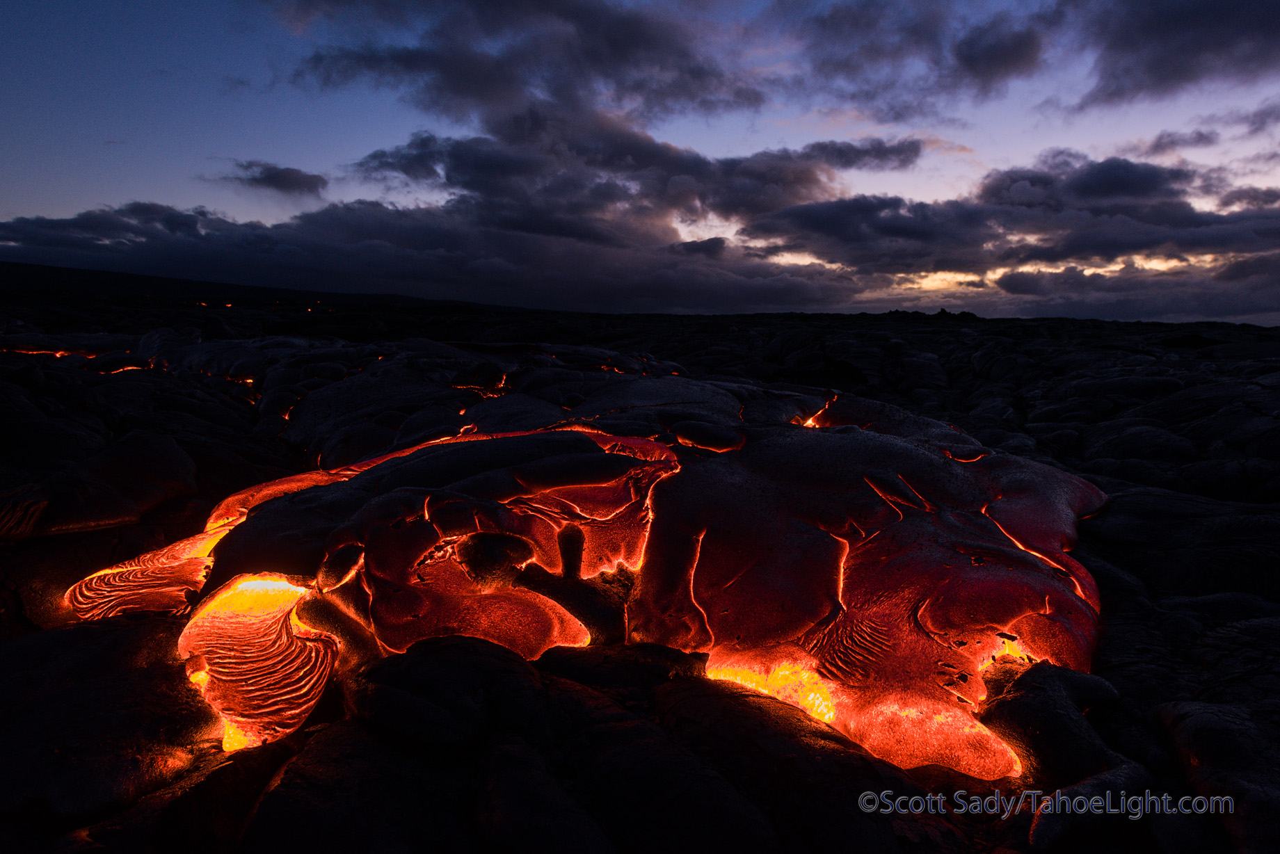 Photographically the lava presents many problems. During the day, even the big flowing breakouts appear a dull orange. During the blue of dusk and dawn things look the best to me, but if you have any breakout, or moving lava, it is so intensely yellow and bright that it was impossible to photograph with a digital camera without going out of gamut. So I started looking for formations that were starting to cool and no longer moving and found those balanced out the best.