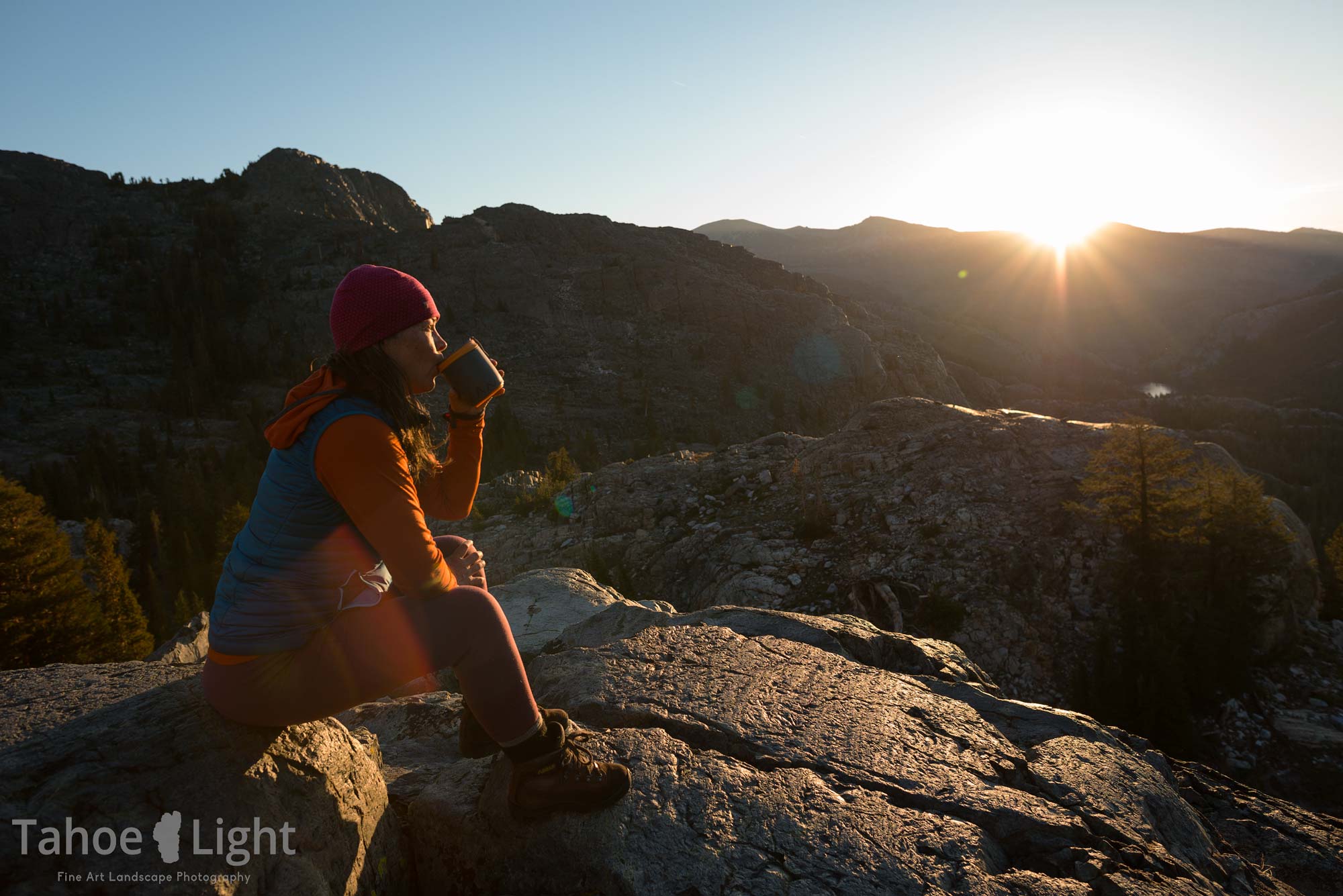 woman hiker drinking coffee at sunrise
