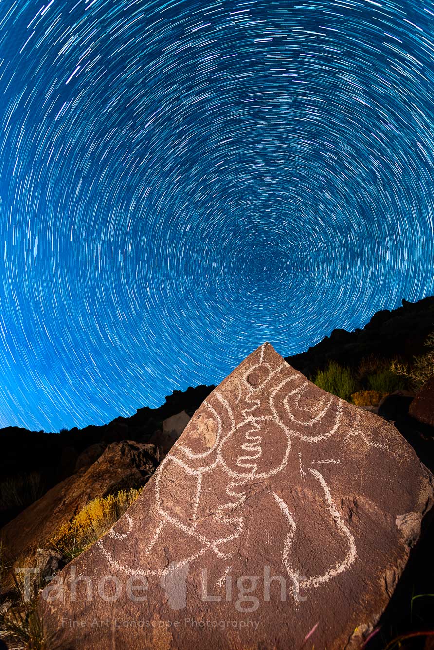 stars rotating above petroglyph at night