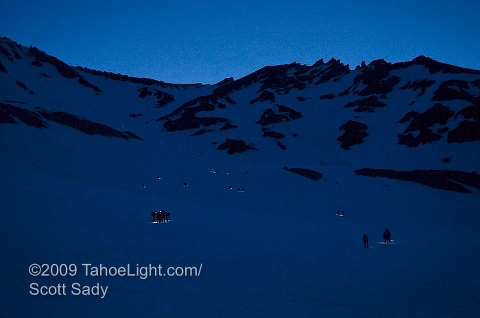 A string of pre-dawn climbers look like fireflys on their climb up to red banks from Helen Lake.