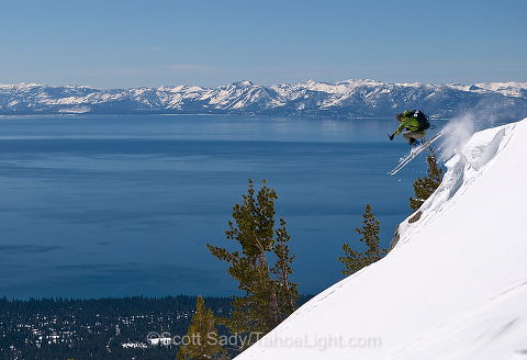 snow skier jumping with lake tahoe in background
