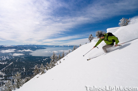 skier making turns withe lake tahoe in background