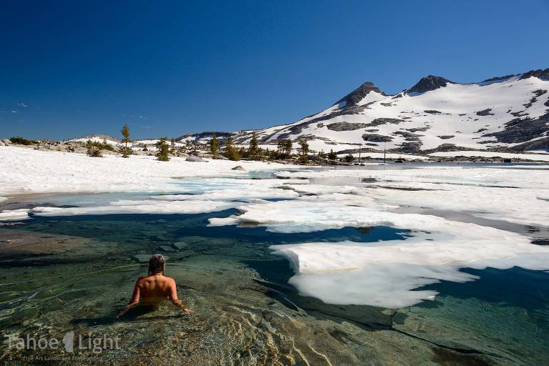 woman sits in icy lake