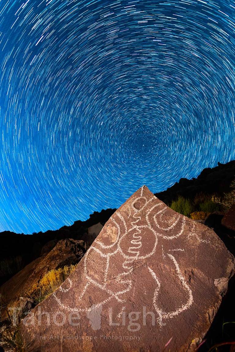 stars rotating above petroglyph at night