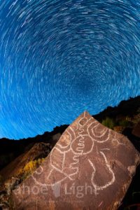 stars rotating above petroglyph at night